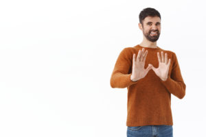 Bearded man holding hands up grimacing
